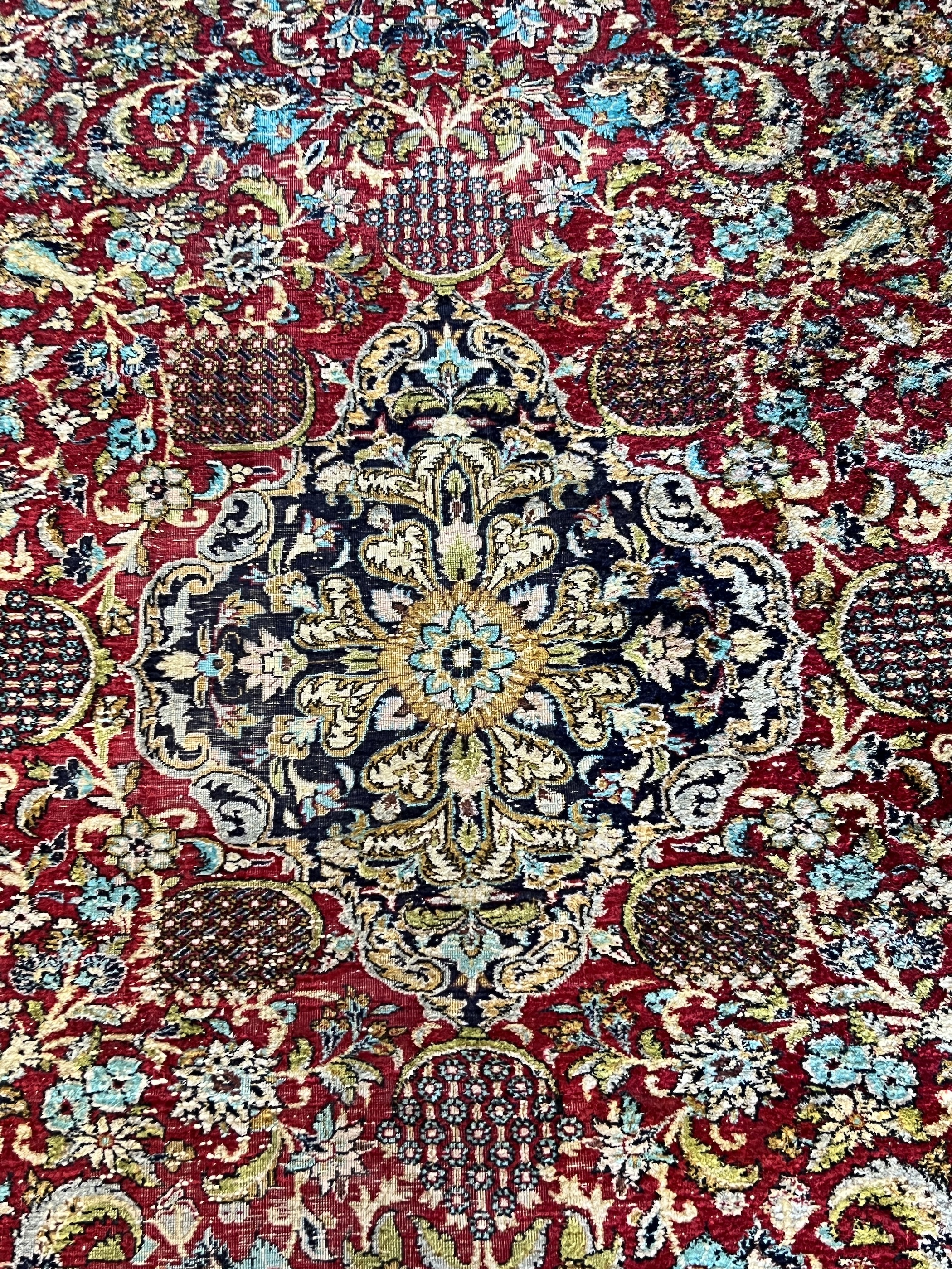 A Tabriz part silk burgundy ground rug, 218 x 150cm